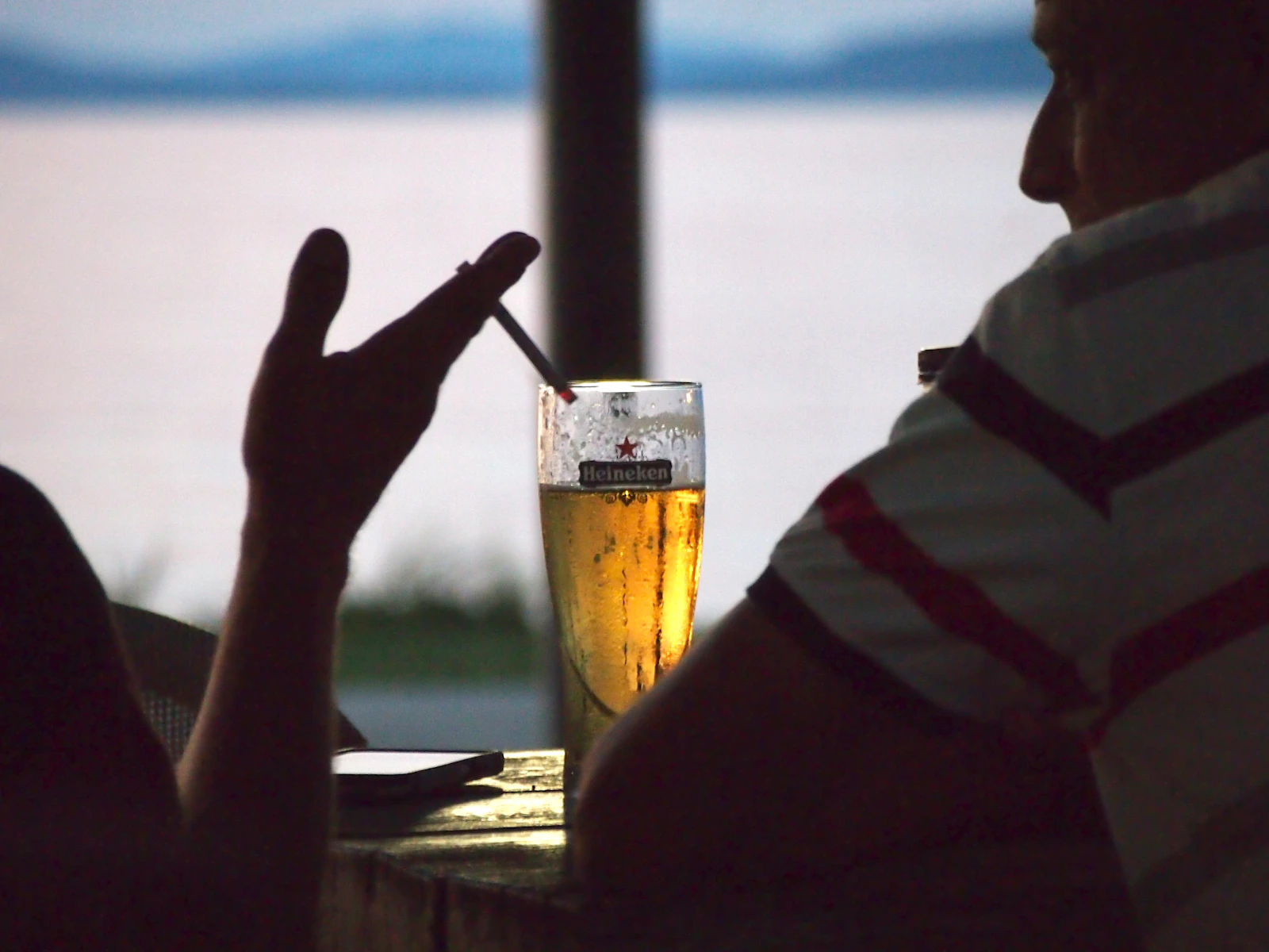 Phone and drink on a table at dusk, illustrating fast relief and choices in ADHD and addiction